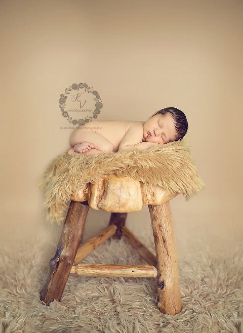 newborn on organic wood stool