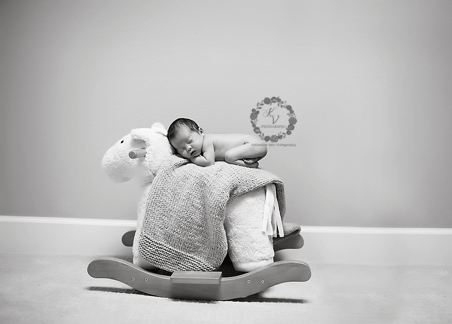 newborn on rocking horse
