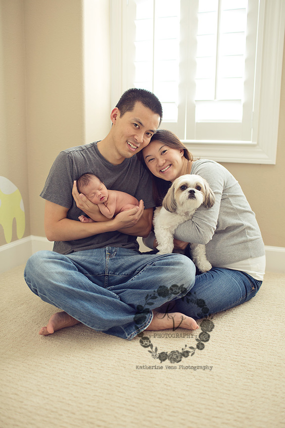 newborn with mom, dad, dog in nursery