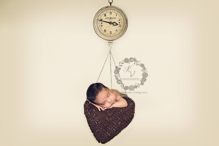 newborn in hanging scale