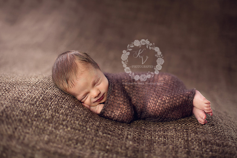 newborn wrapped, smiling