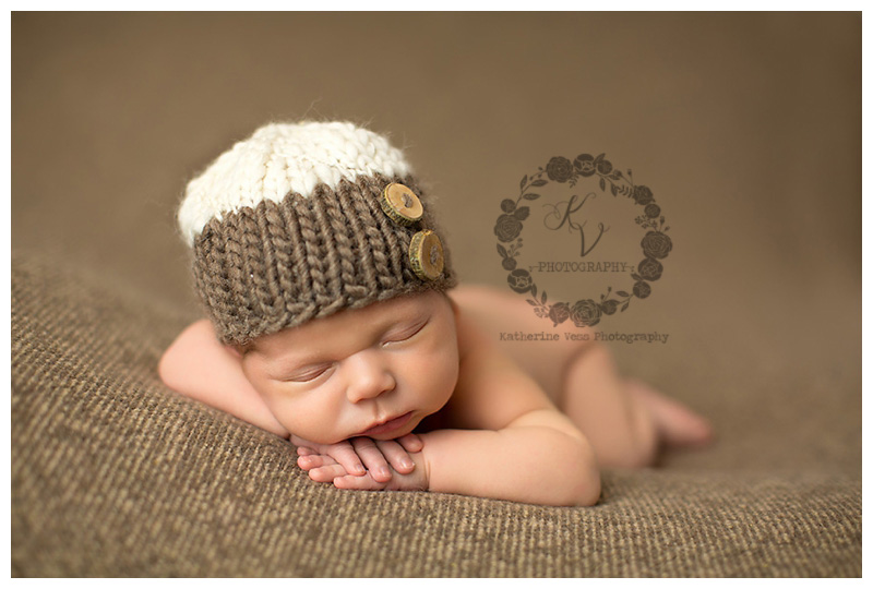 newborn boy in cute wood button hat
