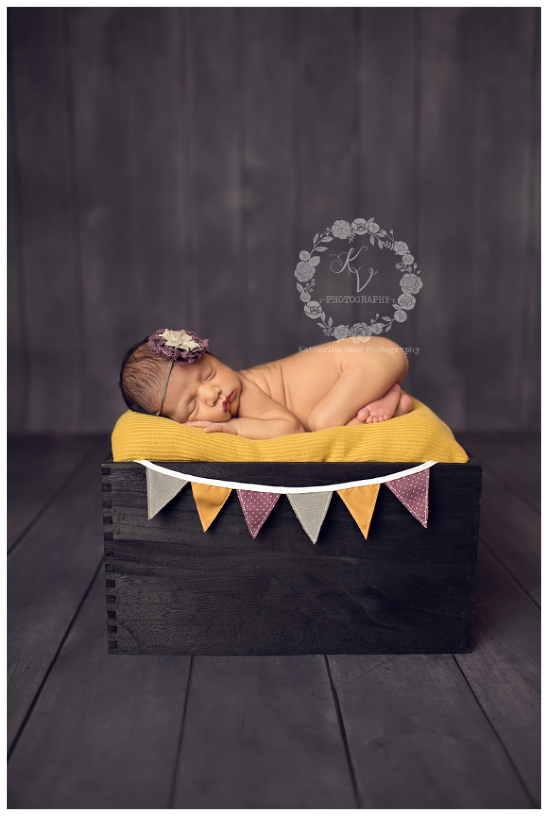 Newborn girl with gray, purple, mustard yellow