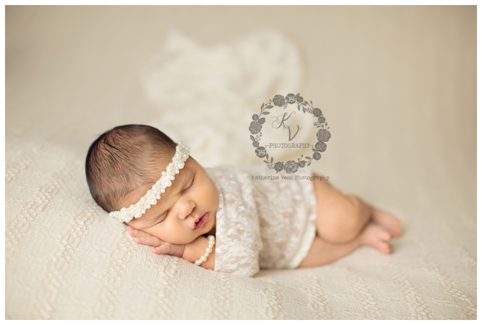 baby newborn girl in white lace and pearls